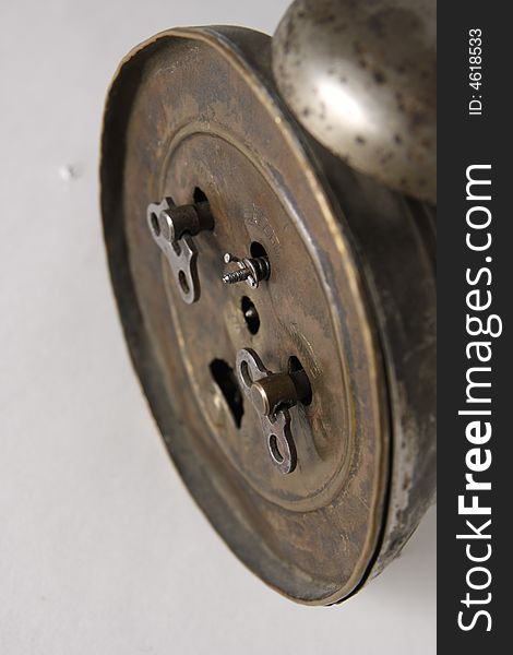 The backside of an old alarm-clock. Clockwork keys. The backside of an old alarm-clock. Clockwork keys.