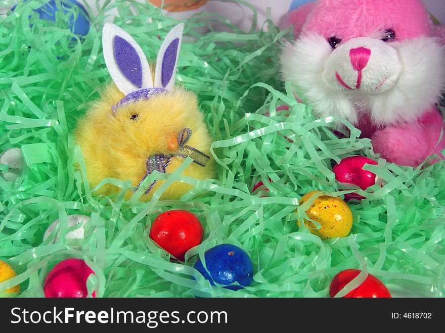 Bunny and chick in fake grass with candy eggs. Bunny and chick in fake grass with candy eggs.