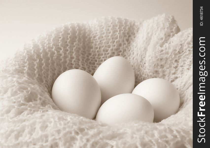 Image of four white eggs sitting in a bowl covered with a finely crocheted shawl.  Black and white with horizontal orientation. Image of four white eggs sitting in a bowl covered with a finely crocheted shawl.  Black and white with horizontal orientation.