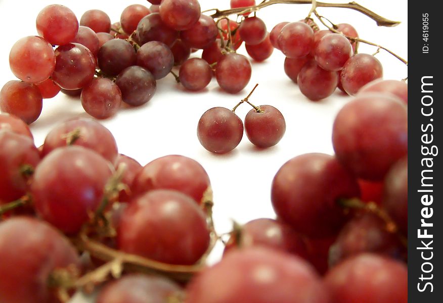 Image of red grapes forming a ring around two joined together.  White background.  Horizontal orientation. Image of red grapes forming a ring around two joined together.  White background.  Horizontal orientation.