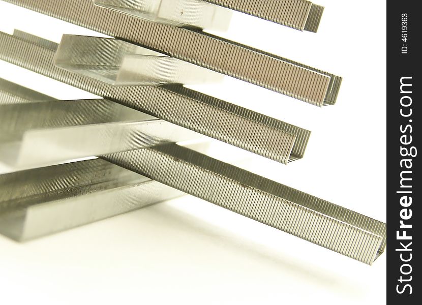 Image of a structure made of rows of metal replacement staples.  White background and Horizontal orientation. Image of a structure made of rows of metal replacement staples.  White background and Horizontal orientation.