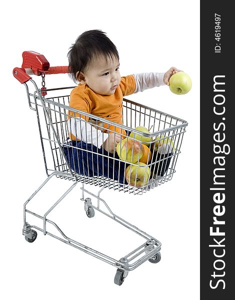 Baby sitting in a shopping cart with fruit before white 
background. Baby sitting in a shopping cart with fruit before white 
background