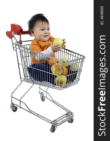 Baby sitting in a shopping cart with fruit before white 
background. Baby sitting in a shopping cart with fruit before white 
background