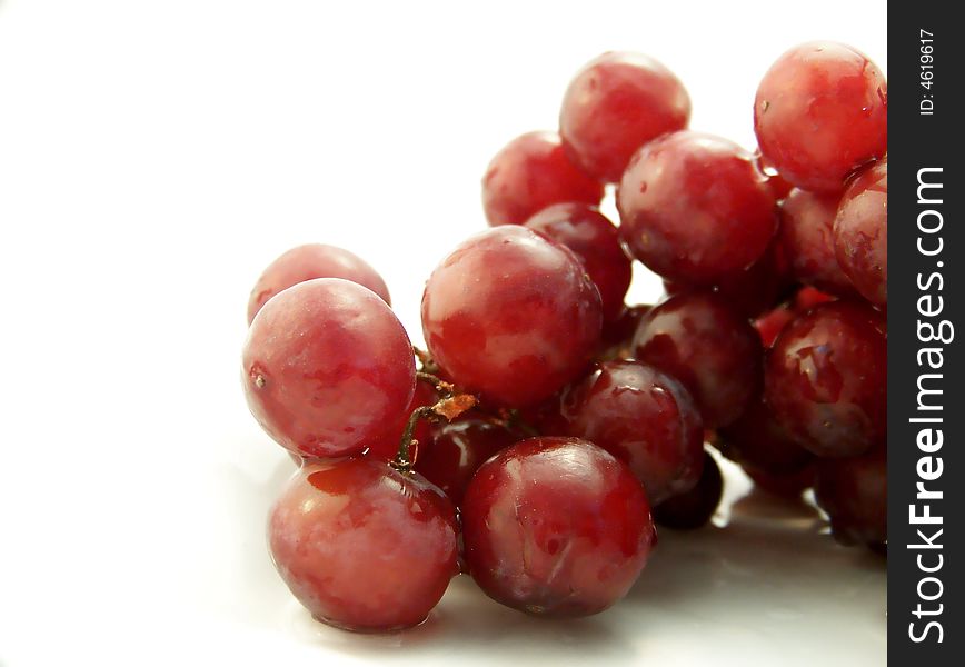 Image of wet red grapes, on white background.  Horizontal orientation. Image of wet red grapes, on white background.  Horizontal orientation.
