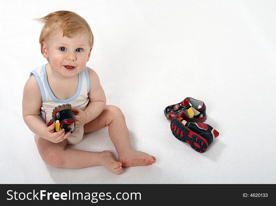 The beautiful little boy tries on footwear. The beautiful little boy tries on footwear