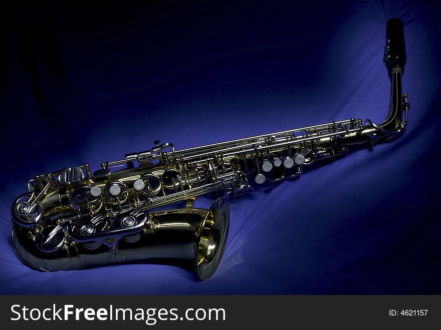 An Alto saxophone against a blue cotton backdrop. An Alto saxophone against a blue cotton backdrop.