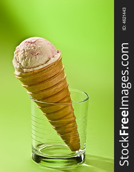 Food series: vanilla cornet on the glass over green. Food series: vanilla cornet on the glass over green