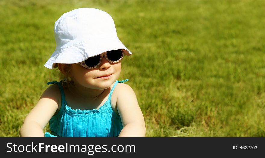 Young girl sits on grass in a Moscow park. Young girl sits on grass in a Moscow park