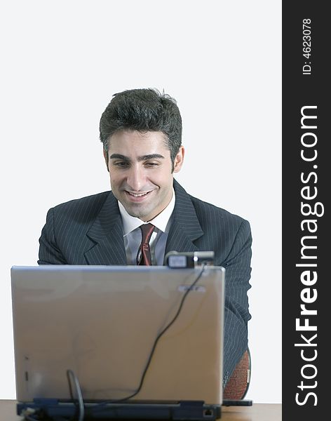 Business man at laptop with a contented smile. Business man at laptop with a contented smile
