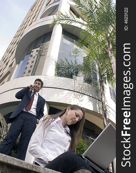 Man and woman in business attire working together outdoors. Man and woman in business attire working together outdoors