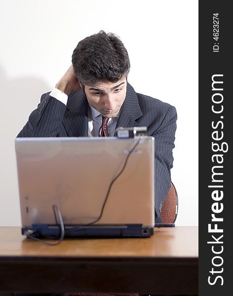 Fed up business man working at a desk. Isolated against a white background. Fed up business man working at a desk. Isolated against a white background