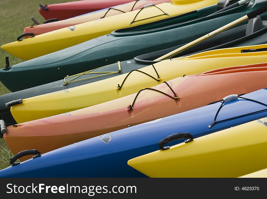 A colorful group of kayaks on the shore. A colorful group of kayaks on the shore.
