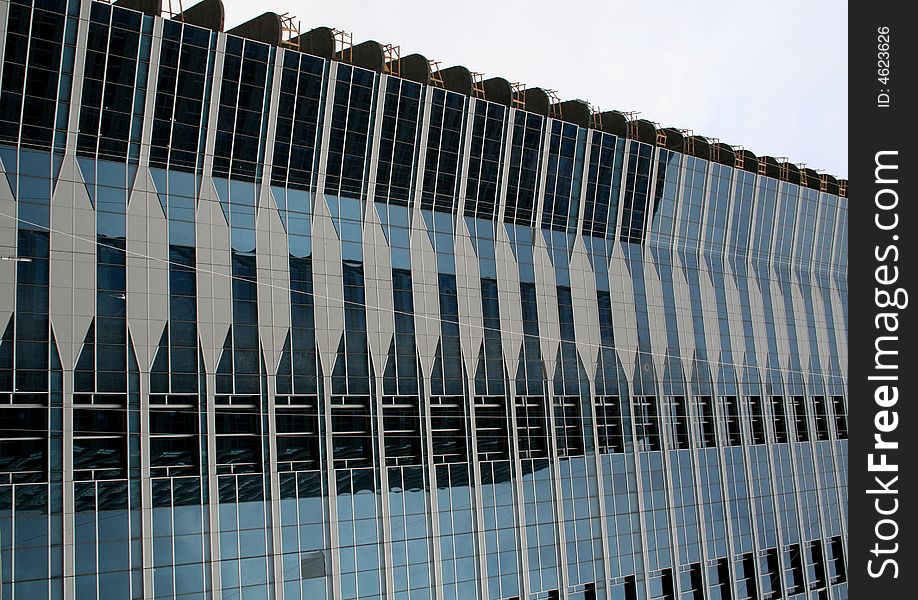 Upward view of building with glass panels, grey patterns and reflections other buildings. Upward view of building with glass panels, grey patterns and reflections other buildings.