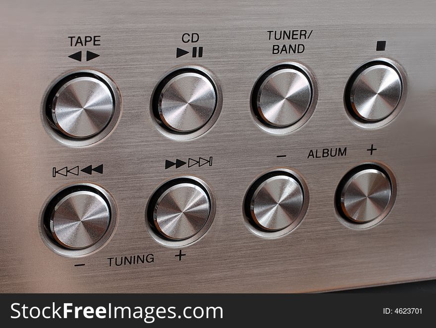 Metallic music control round buttons on aluminum surface