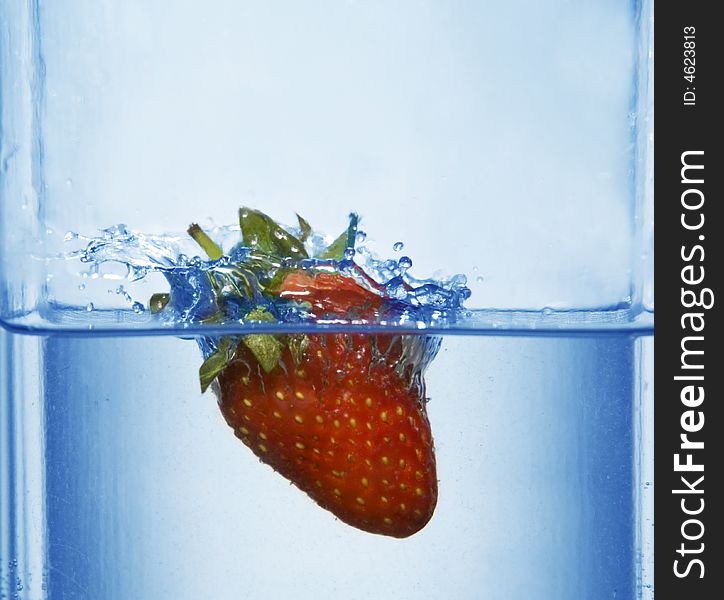 Splashing strawberry into a water. Splashing strawberry into a water