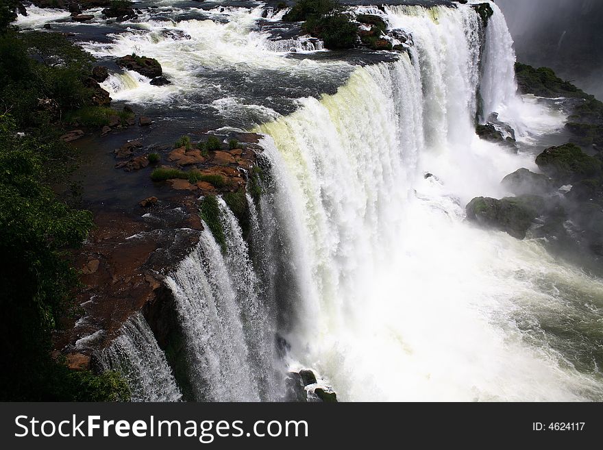 The Iguassu (or Iguazu) Falls is one of the largest masses of fresh water on the planet and divides, in South America, Brazil, Paraguay and Argentina. The waterfall system consists of 275 falls along 2.7 kilometres (1.67 miles) of the Iguazu River. Some of the individual falls are up to 82 metres (269 feet) in height, though the majority are about 64 metres (210 feet). The Iguassu (or Iguazu) Falls is one of the largest masses of fresh water on the planet and divides, in South America, Brazil, Paraguay and Argentina. The waterfall system consists of 275 falls along 2.7 kilometres (1.67 miles) of the Iguazu River. Some of the individual falls are up to 82 metres (269 feet) in height, though the majority are about 64 metres (210 feet).