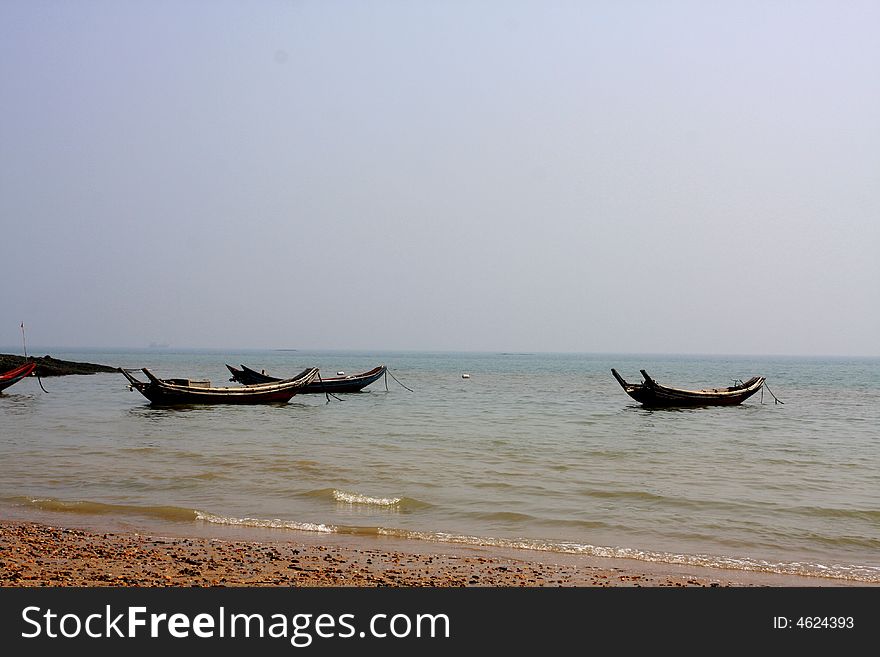 A calm afternoon, beside a Chinese little island, a silent beach some old wood boat parking there. A calm afternoon, beside a Chinese little island, a silent beach some old wood boat parking there.