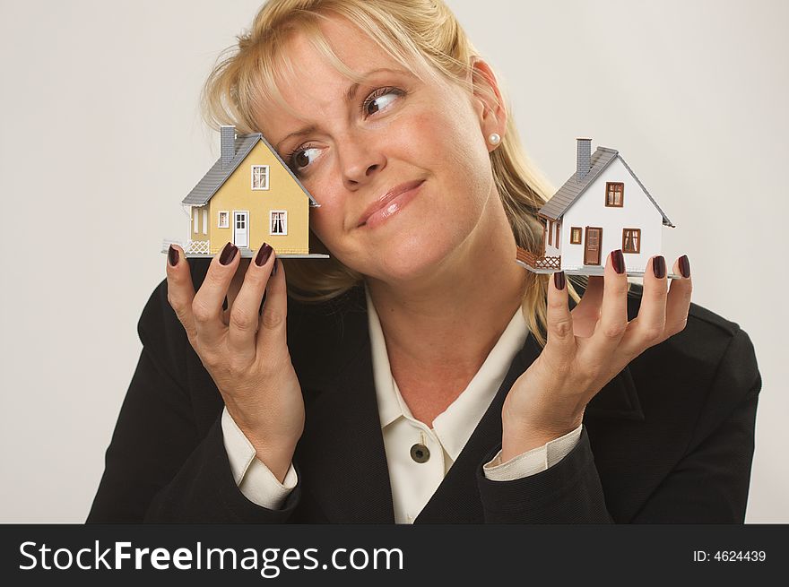 Female dreaming while holding two houses - favoring one. Female dreaming while holding two houses - favoring one.