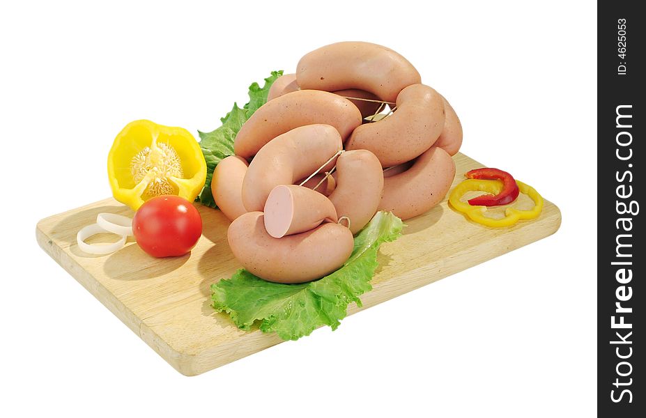 Appetizing sausages with vegetables on the kitchen-board