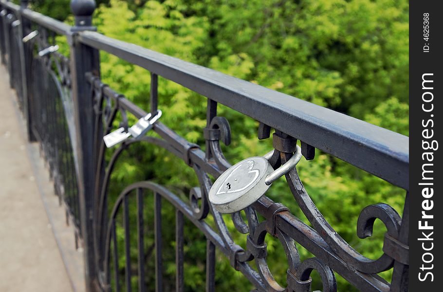 The metal lock with figure on a fencing of the bridge