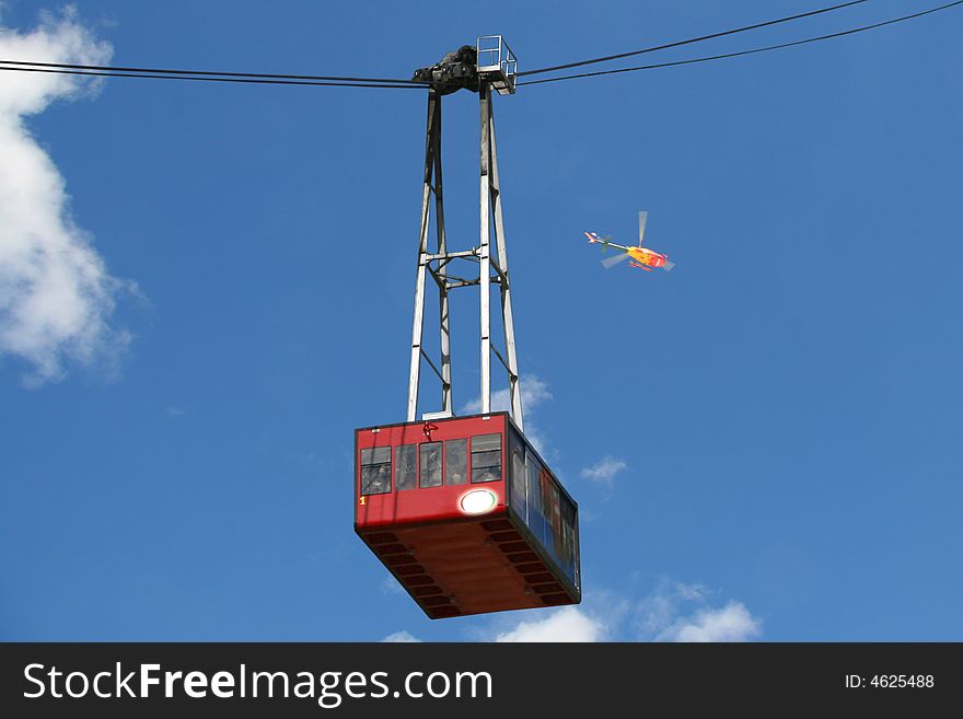 A cable-car with a blue sky in the background. A cable-car with a blue sky in the background