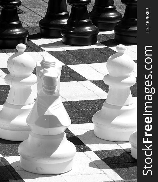 Black and white photograph of outdoor chess pieces