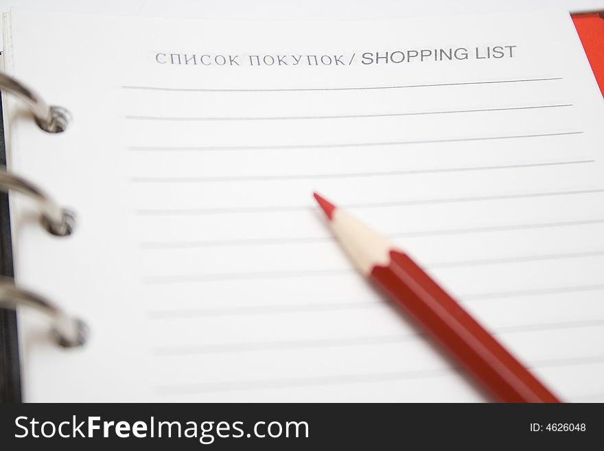 Blank shopping list and red pencil