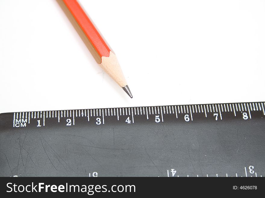 Pencil and black ruller on the white isolated background