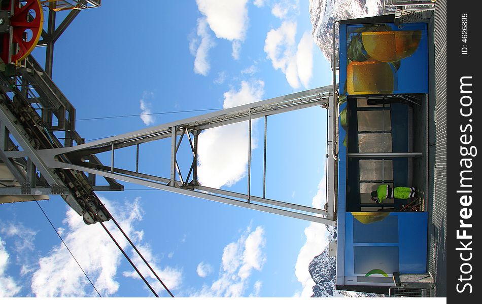 A cable-car with a blue sky in the background. A cable-car with a blue sky in the background