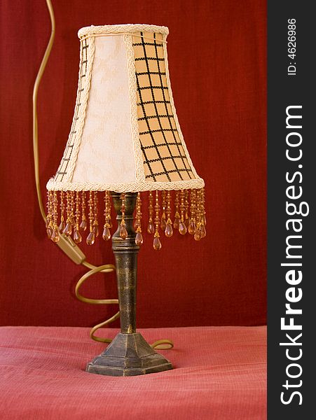 A vintage bedside lamp isolated on red background
