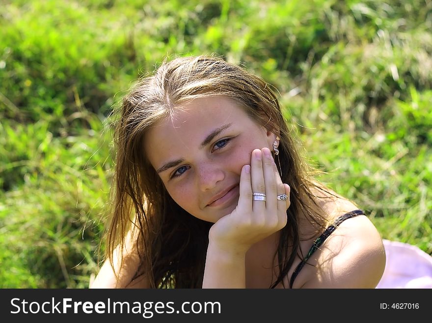 Young beautiful smiling woman on the grass