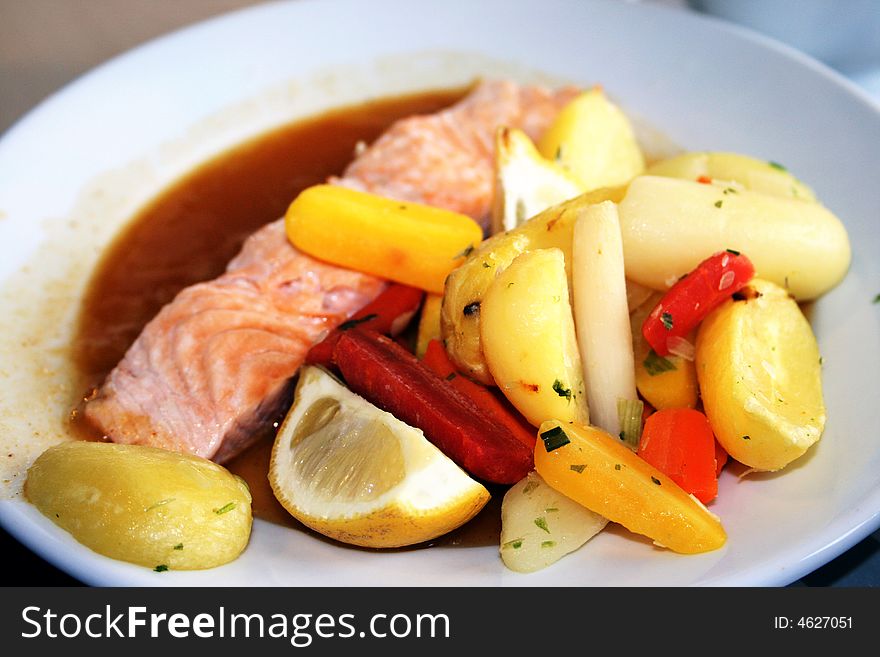 Oven baked salmon on a bed of vegatables with apple glaze