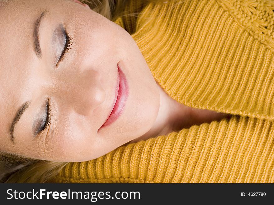 Smiling woman wearing yellow cardigan with eyes closed. Smiling woman wearing yellow cardigan with eyes closed