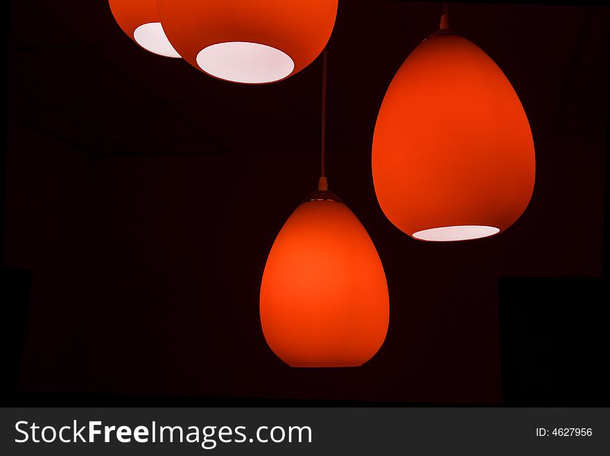 Four red modern lamps in a black room. Four red modern lamps in a black room