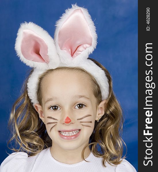 Little smilling girl with bunny ears over blue background