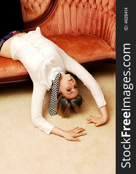 An pretty young girl in a white blouse and black and white tie lying on a pink
sofa whit her head down. An pretty young girl in a white blouse and black and white tie lying on a pink
sofa whit her head down