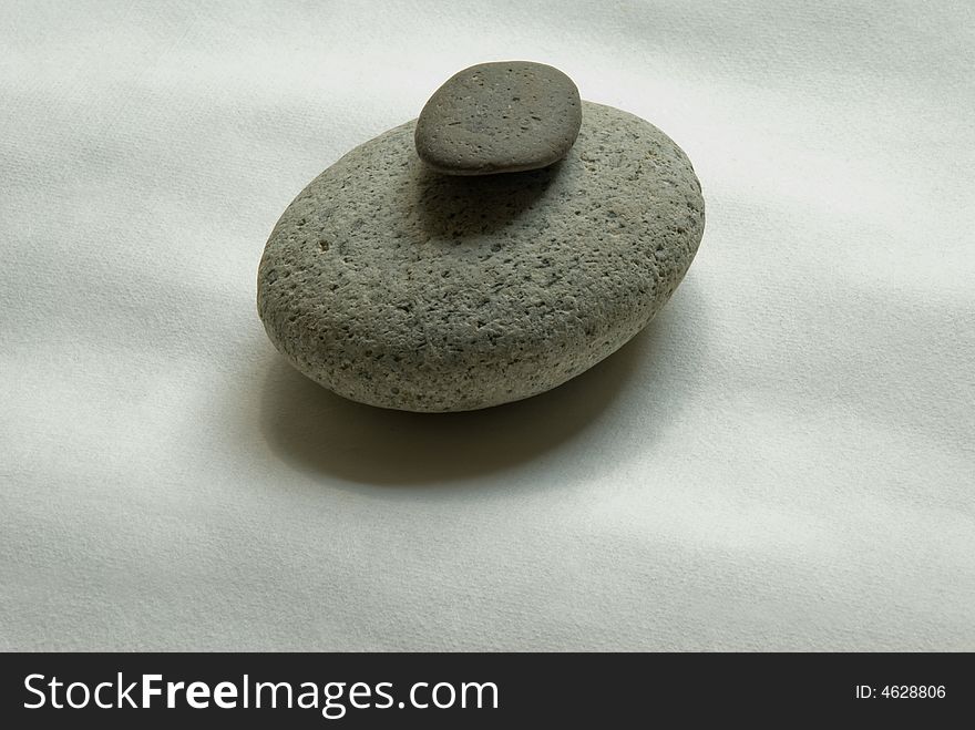 Two rounded stones on a piece of Japanese hand made paper. Two rounded stones on a piece of Japanese hand made paper
