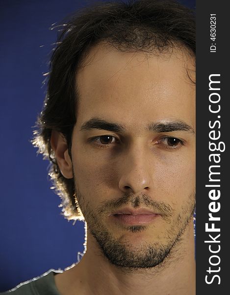 Portrait of pensive young man over blue background. Portrait of pensive young man over blue background