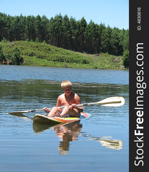Boy is paddling on a calm lake. Boy is paddling on a calm lake