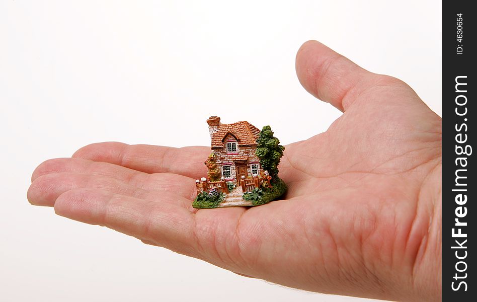 A small porcelain figurine of a country house on the human hand. A small porcelain figurine of a country house on the human hand.