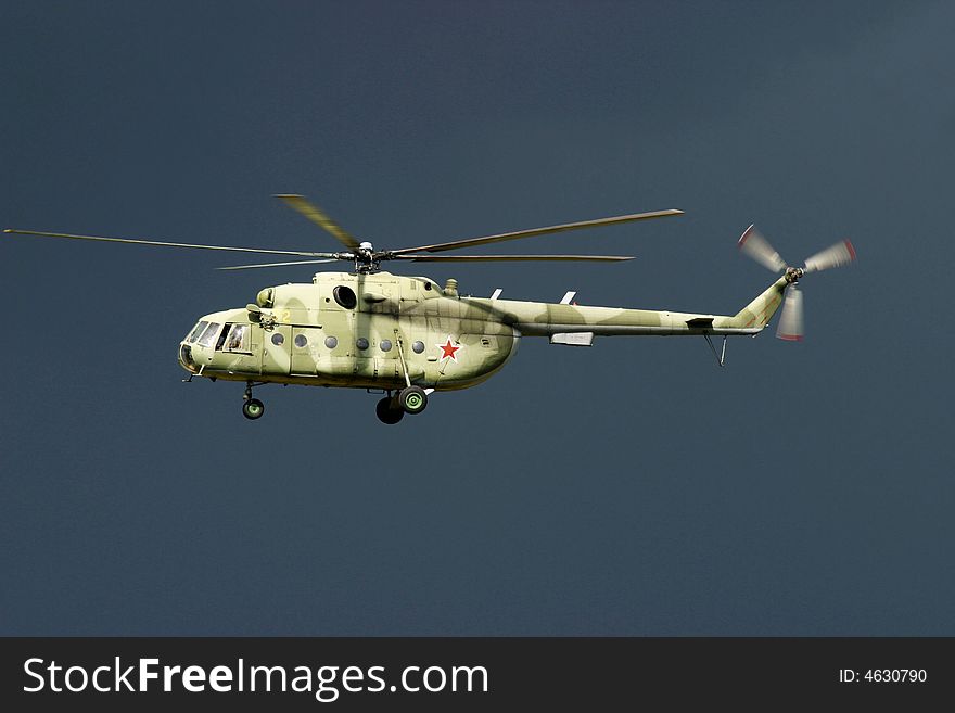 A Russian military transport helicopter, sunlit on the backdrop of the dark cloud. A Russian military transport helicopter, sunlit on the backdrop of the dark cloud.
