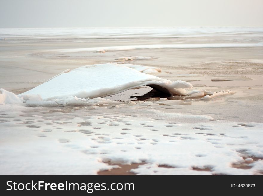 Snow coast of the frozen lake in the early spring