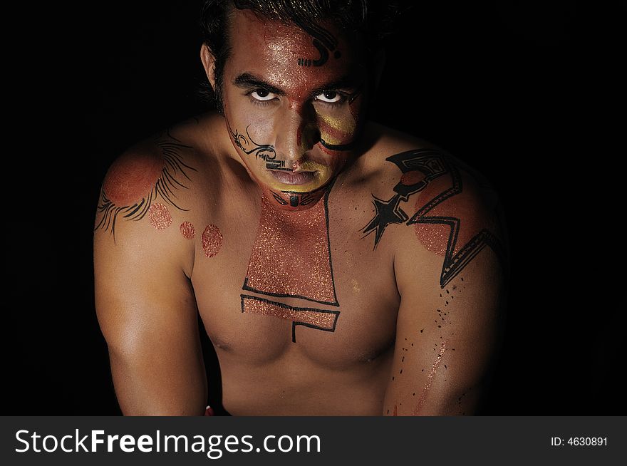 Portrait of latin young male with intense look and bodypaint drawing. Portrait of latin young male with intense look and bodypaint drawing