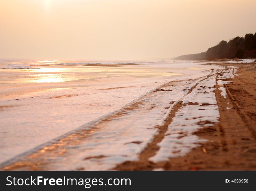 Snow coast of the frozen lake in the early spring