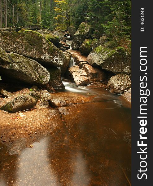 The water of a torrent flow between mountain rocks