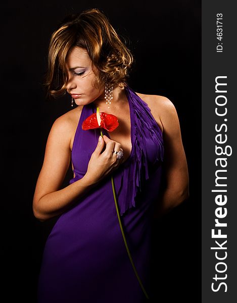 Young fashion woman holding exotic flower isolated on black. Young fashion woman holding exotic flower isolated on black