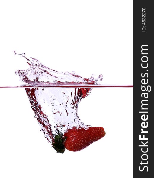 Splashing strawberry into the water over white background
