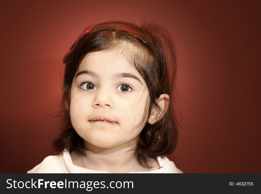 A close-up portrait of a two year old with a brown background. A close-up portrait of a two year old with a brown background