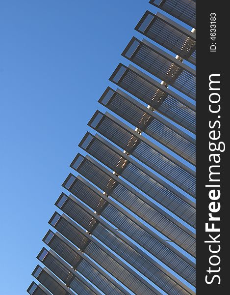 Detail of a modern architectural structure with steel panels attached to a steel rod and blue sky providing background. Detail of a modern architectural structure with steel panels attached to a steel rod and blue sky providing background.