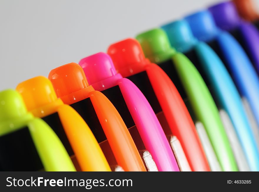 A row of colourful pen caps